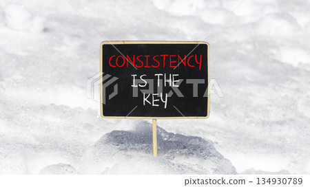 Consistency is the key symbol. Concept words Consistency is the key on beautiful blackboard. Beautiful white snow background. Business consistency is the key concept. Copy space. 134930789