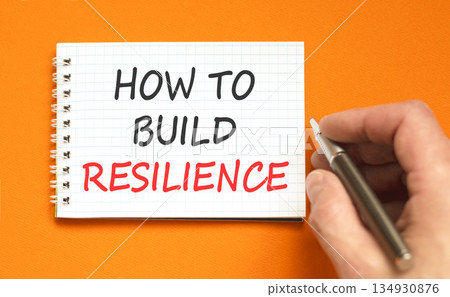 How to build resilience symbol. Concept words How to build resilience on beautiful white note. Beautiful orange background. Businessman's hand. Business how to build resilience concept. Copy space. How to build resilience symbol. Concept words How to build resilience on beautiful white note. Beautiful orange background. Businessman's hand. Business how to build resilience concept. Copy space. 134930876