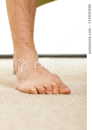 Closeup of man foot standing on carpet 134930896