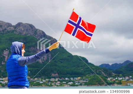 Tourist with norwegian flag on fjord 134930996