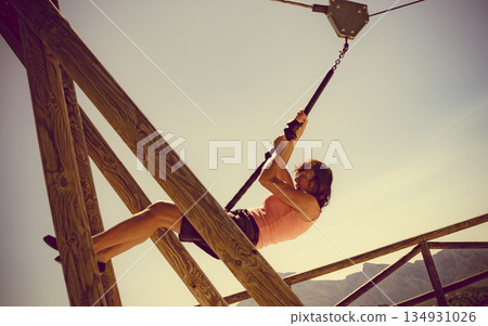 Adult woman having fun on zipline Adult woman having fun on zipline 134931026