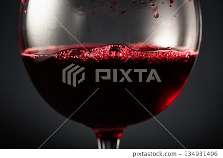 Red wine of rich dark color being poured into a glass. Red wine of rich dark color being poured into a glass. 134931406