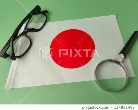The image prominently features this flag, along with a pair of reading glasses and a magnifying glass. The image prominently features this flag, along with a pair of reading glasses and a magnifying glass. 134931492