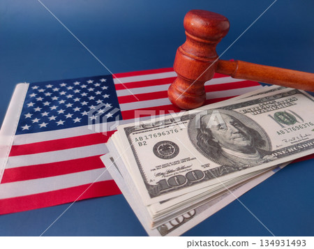 Stack of U.S. one-hundred dollar bills with a judge's gavel and a small American flag, symbolizing U.S. law and finance. Stack of U.S. one-hundred dollar bills with a judge's gavel and a small American flag, symbolizing U.S. law and finance. 134931493