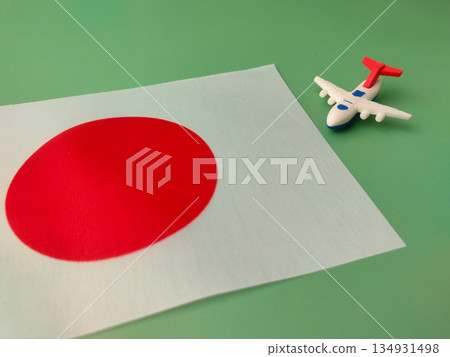 Small toy airplane positioned over the national flag of Japan, symbolizing air travel to the country. Small toy airplane positioned over the national flag of Japan, symbolizing air travel to the country. 134931498