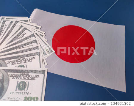 The image displays United States currency notes alongside the national flag of Japan. 134931502