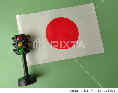 The image displays a miniature Japanese flag alongside a miniature traffic light. The image displays a miniature Japanese flag alongside a miniature traffic light. 134931503