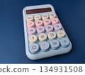Top view pastel-colored desktop calculator featuring a retro typewriter style with large, round mechanical keys. 134931508
