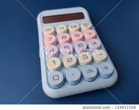 Top view pastel-colored desktop calculator featuring a retro typewriter style with large, round mechanical keys. Top view pastel-colored desktop calculator featuring a retro typewriter style with large, round mechanical keys. 134931508