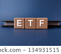 The image displays wooden blocks spelling out ETF, which stands for Exchange-Traded Fund. 134931515