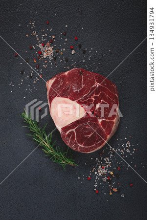 a shank on the bone, raw meat for ossobuco, on the table, with a branch of rosemary, top view, no people, a shank on the bone, raw meat for ossobuco, on the table, with a branch of rosemary, top view, no people, 134931794