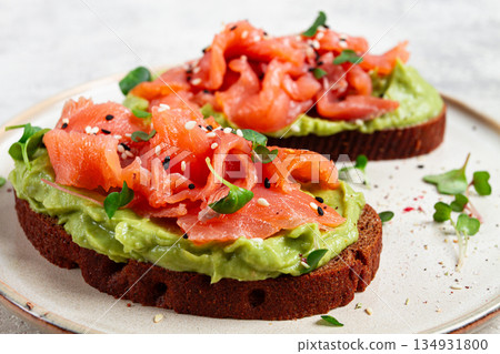 breakfast, Sandwiches with smoked salmon and avocado, on dark rye bread, with microgreens, on a marble table, homemade, no people, breakfast, Sandwiches with smoked salmon and avocado, on dark rye bread, with microgreens, on a marble table, homemade, no people, 134931800