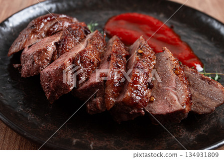 roast duck breast, sliced on a plate, with red sauce, homemade, no people, 134931809