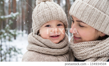 The tenderness of a child in mother's arms in the winter 134934504