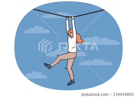 Frightened woman faces risk and danger as she navigates way along rope suspended high in sky Frightened woman faces risk and danger as she navigates way along rope suspended high in sky 134934603