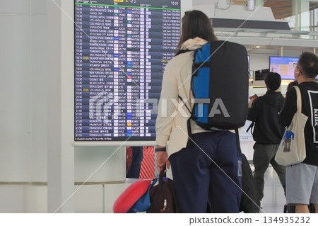 遊客在機場查看時刻表 飛機時刻表 遊客在機場查看時刻表 飛機時刻表 134935232