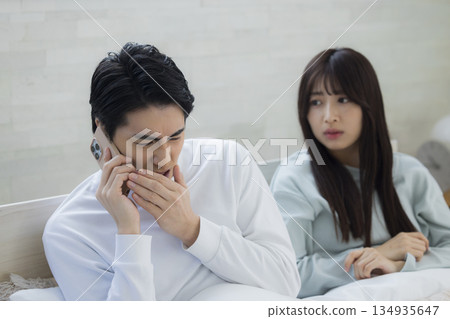 Couple looking at smartphone in bed Couple looking at smartphone in bed 134935647