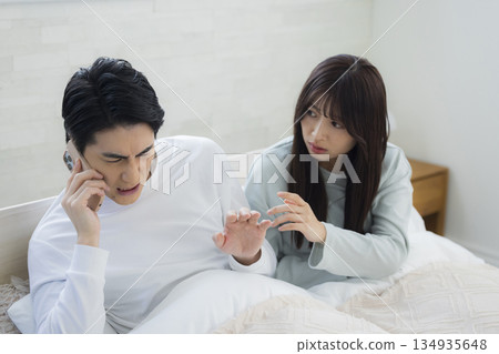 夫婦在床上看智慧型手機 134935648