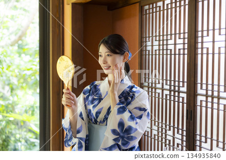 A woman in a yukata sitting on the edge A woman in a yukata sitting on the edge 134935840