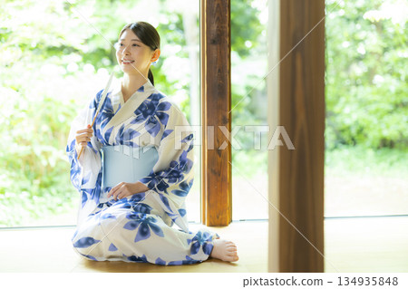 A woman in a yukata sitting on the edge A woman in a yukata sitting on the edge 134935848