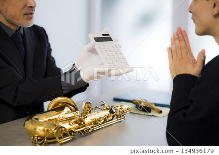 A man appraising a saxophone 134936179