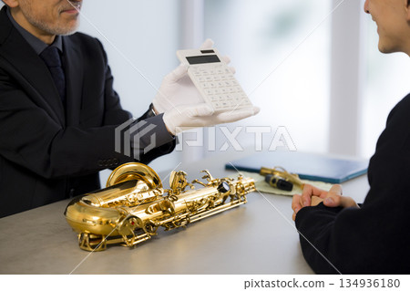 一名男子正在鑑定一支薩克斯風 134936180