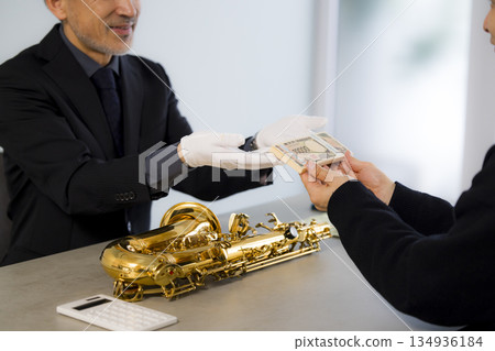 A man appraising a saxophone A man appraising a saxophone 134936184