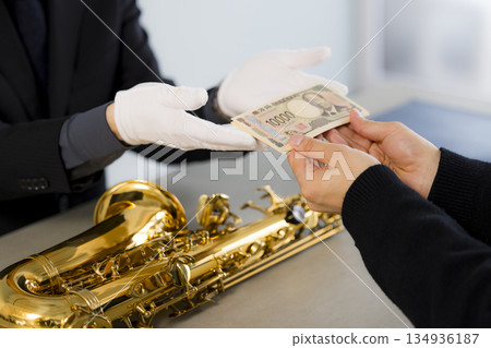 一名男子正在鑑定一支薩克斯風 134936187