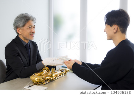 一名男子正在鑑定一支薩克斯風 134936188