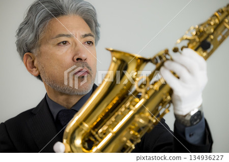 A man appraising a saxophone A man appraising a saxophone 134936227