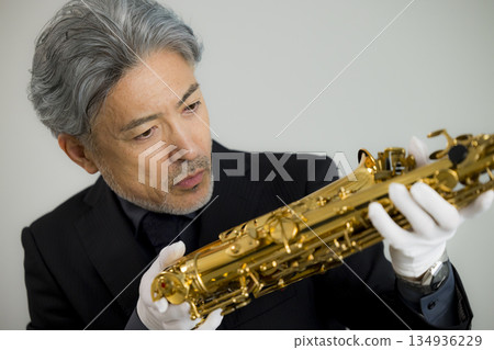 A man appraising a saxophone A man appraising a saxophone 134936229