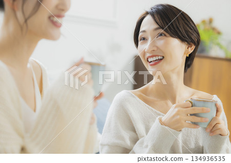 Woman drinking hot coffee in her room Woman drinking hot coffee in her room 134936535