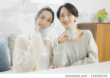 一個女人在她的房間裡喝熱咖啡 一個女人在她的房間裡喝熱咖啡 134936536