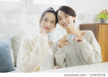 一個女人在她的房間裡喝熱咖啡 一個女人在她的房間裡喝熱咖啡 134936538