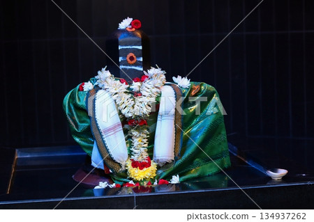 Hindu Shiva lingam inside a Kuala Lumpur, Malaysia temple, decorated with flowers, symbolizing spirituality and religious devotion. 134937262