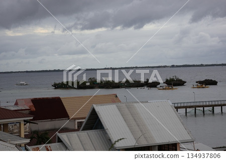 A view from a hotel in Cebu, with a cloudy sky, buildings, islands, the sea, ships, and land on the opposite shore. A view from a hotel in Cebu, with a cloudy sky, buildings, islands, the sea, ships, and land on the opposite shore. 134937806