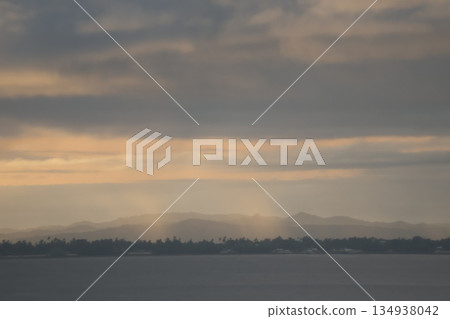 A landscape of the sea, cloudy sky, crepuscular rays, the opposite coast, forest, and hazy mountains A landscape of the sea, cloudy sky, crepuscular rays, the opposite coast, forest, and hazy mountains 134938042