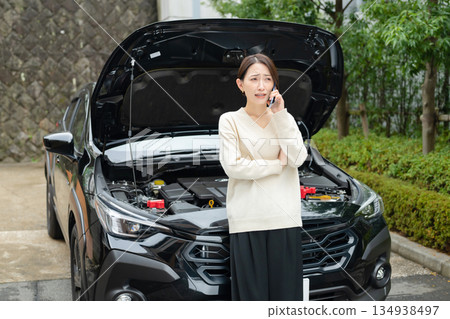 Woman making a phone call in front of a car Woman making a phone call in front of a car 134938497