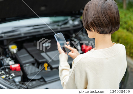 一名女子在車前打電話 一名女子在車前打電話 134938499