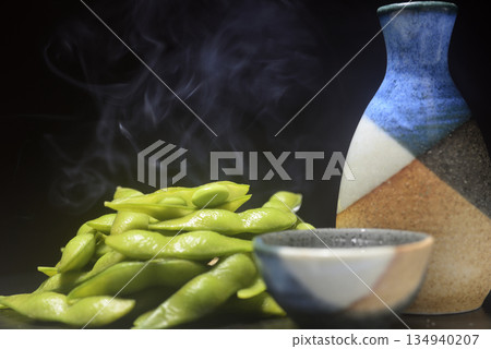 Steaming freshly boiled edamame beans and sake in a sake bottle Steaming freshly boiled edamame beans and sake in a sake bottle 134940207