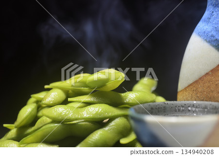 Steaming freshly boiled edamame beans and sake in a sake bottle 134940208