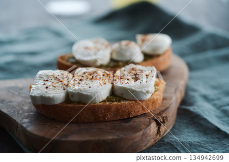 Open sandwich with pesto and mozzarella on linen cloth 134942699