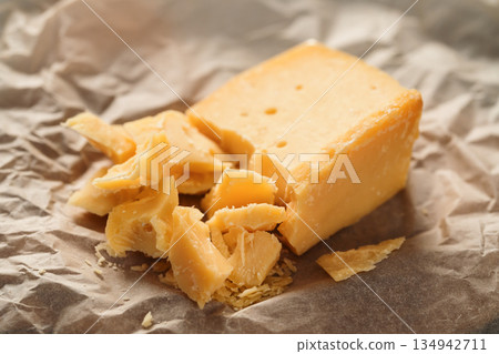 pieces of aged hard cheese on paper pieces of aged hard cheese on paper 134942711