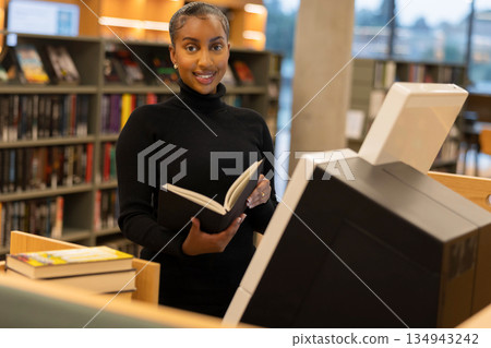 Librarian Utilizes Self-Service Library Terminal Librarian Utilizes Self-Service Library Terminal 134943242