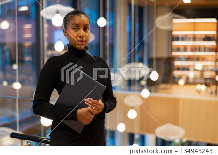 Confident student in modern library Confident student in modern library 134943243