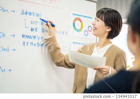 一位年輕女子在商務會議上做解釋 一位年輕女子在商務會議上做解釋 134943317