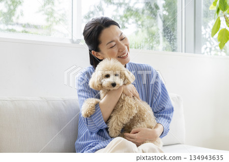 Middle-aged woman holding her pet dog 134943635