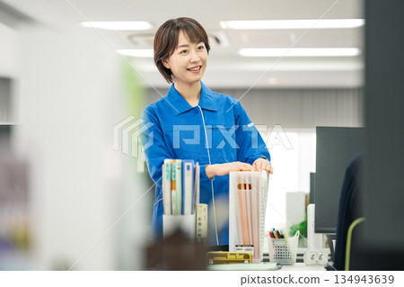 A young woman in work clothes working in an office A young woman in work clothes working in an office 134943639