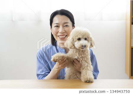 一位五十多歲的女士和她的寵物狗對著鏡頭說話 134943750