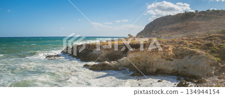 Mediterranean seascape during windy but sunny weather with waves breaking on the shore. 134944154